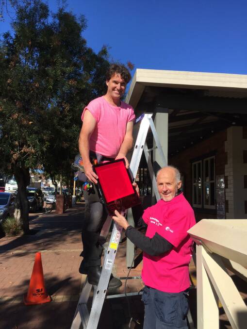 Power of Pink: Ian Rooke and Quentin Bligh from Wilderness Electrics get to work installing the bright pink lights that will light up Margaret River's Main Street in August. Photo: Supplied.